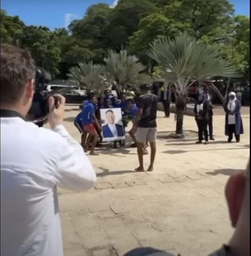 VIDEO HALUCINANT DIN TIMPUL TURNEULUI PREZIDENȚIAL/”Hakuna matata, Iohanes”. După ce strigă Hakuna matata, unul dintre localnici, cel care are tabloul cu unul dintre Iohanniși, o rupe la fugă pe un ponton și se aruncă în apă cu mare entuziasm, cu tot cu tablou